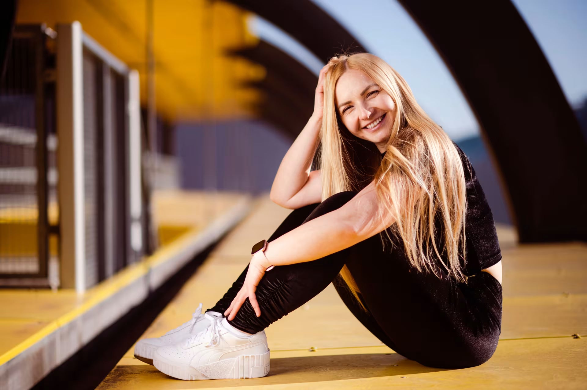 Woman sitting on a platform with a modern building in the background